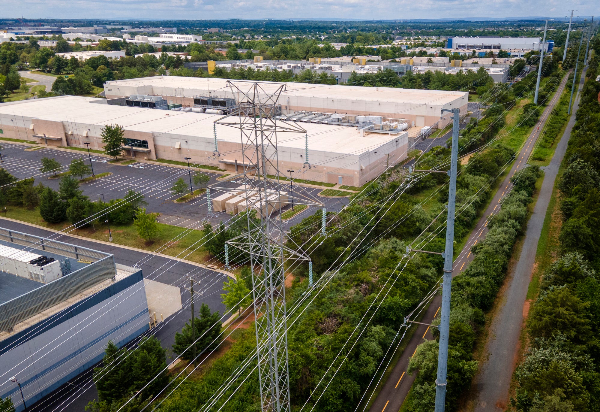 An aerial photo of large buildings with power lines in the foreground